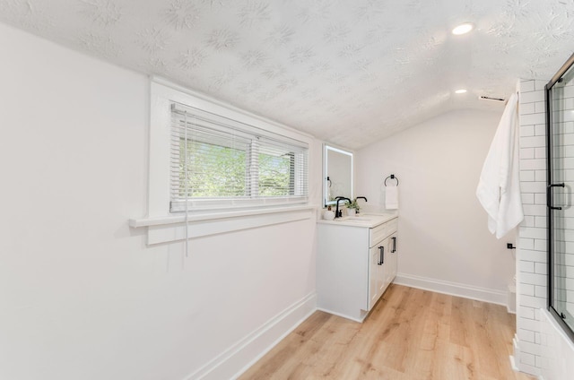 laundry room with a textured ceiling, baseboards, light wood-style flooring, and recessed lighting