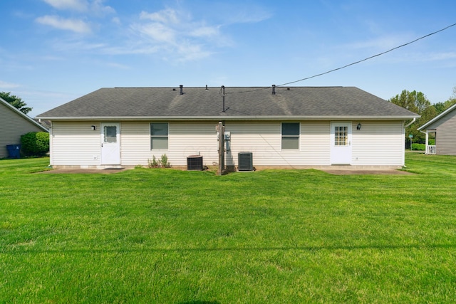 back of property with roof with shingles, a patio, central AC, and a lawn