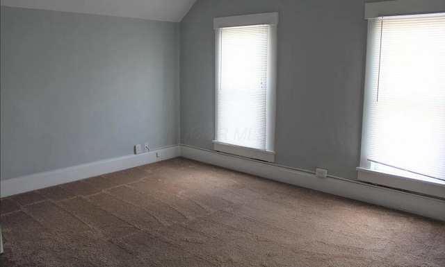 carpeted spare room featuring lofted ceiling, baseboard heating, baseboards, and a healthy amount of sunlight