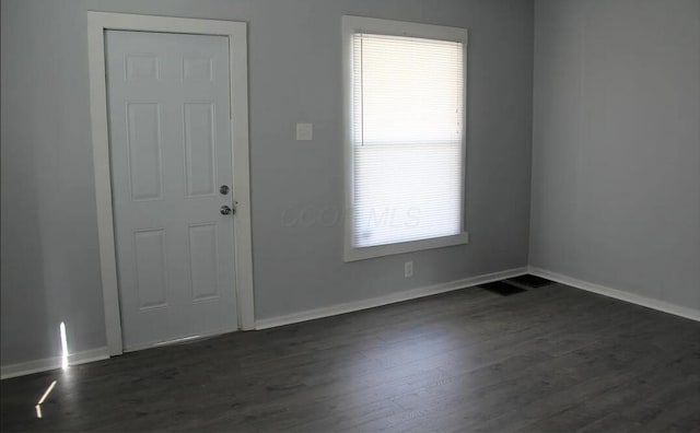interior space featuring baseboards and dark wood-type flooring