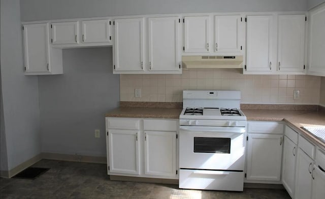 kitchen featuring under cabinet range hood, tasteful backsplash, white gas range oven, and white cabinets