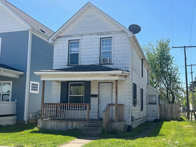 view of front of home with a porch, a front lawn, and fence