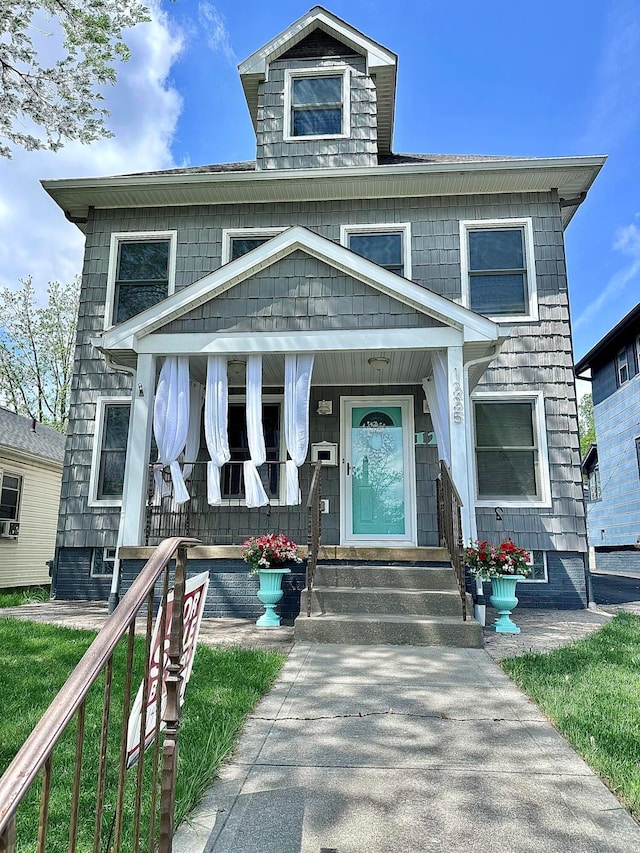 american foursquare style home featuring a porch