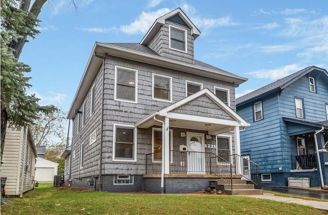 american foursquare style home with covered porch, a front lawn, and central AC