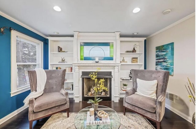 sitting room featuring wood finished floors, visible vents, baseboards, ornamental molding, and recessed lighting