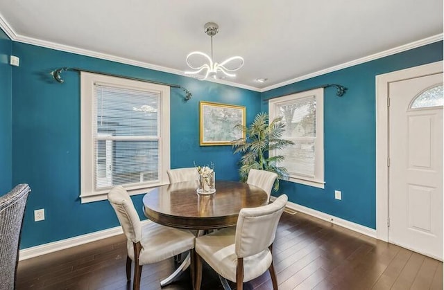 dining space with dark wood-style flooring, ornamental molding, a notable chandelier, and baseboards