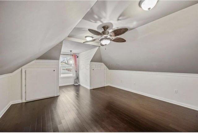 additional living space featuring lofted ceiling, baseboards, a ceiling fan, and dark wood finished floors