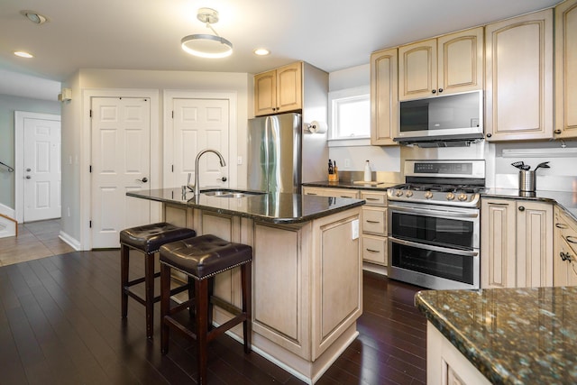 1225 Eastview Ave, Columbus, OH 43212 - kitchen featuring appliances with stainless steel finishes, a sink, a breakfast bar area, recessed lighting, and dark stone countertops