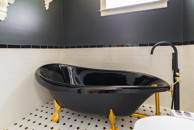 1225 Eastview Ave, Columbus, OH 43212 - bathroom view of tile patterned floors, a freestanding tub, and tile walls