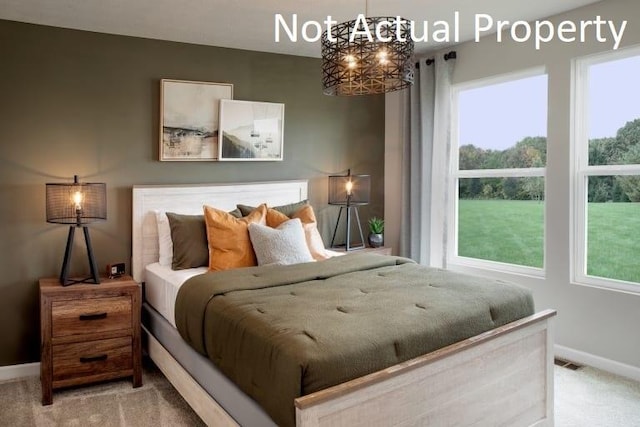 carpeted bedroom with a chandelier, baseboards, and visible vents