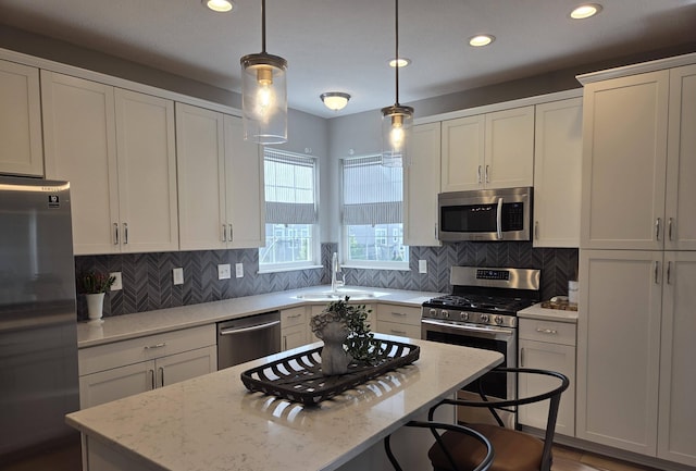 kitchen featuring stainless steel appliances, recessed lighting, a sink, and a kitchen island