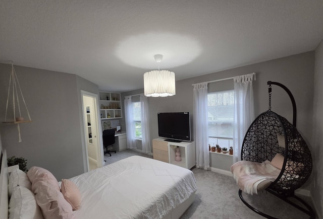 bedroom featuring a textured ceiling, light carpet, and baseboards