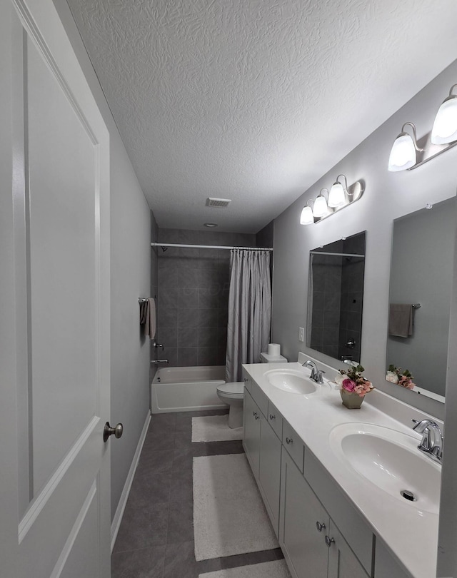full bathroom featuring a sink, a textured ceiling, visible vents, and tile patterned floors