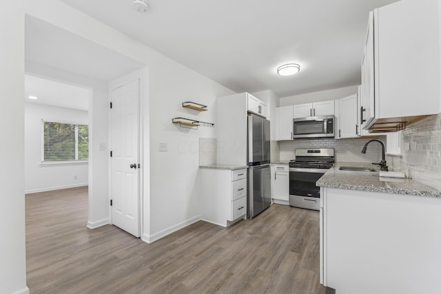 3110 Gerbert Rd, Columbus, OH 43224 - kitchen featuring a sink, stainless steel appliances, tasteful backsplash, and wood finished floors