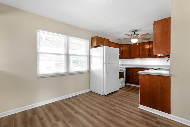 3935 Hillman Rd W, Columbus, OH 43207 - kitchen with a ceiling fan, baseboards, dark wood-style flooring, white appliances, and visible vents