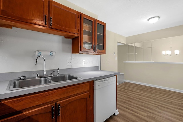 3935 Hillman Rd W, Columbus, OH 43207 - kitchen featuring a sink, brown cabinets, dark wood-style flooring, glass insert cabinets, and white dishwasher