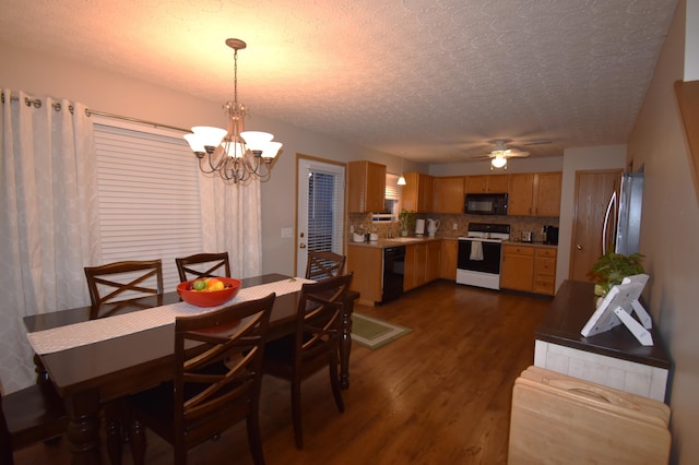 dining area with a textured ceiling, dark wood-type flooring, and ceiling fan with notable chandelier