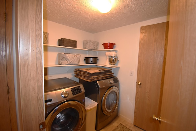 clothes washing area featuring washing machine and dryer, laundry area, and a textured ceiling