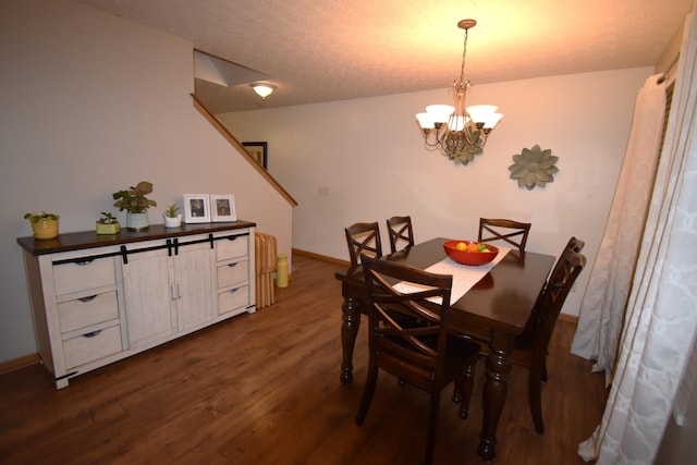dining room with a textured ceiling, a notable chandelier, dark wood-type flooring, and baseboards
