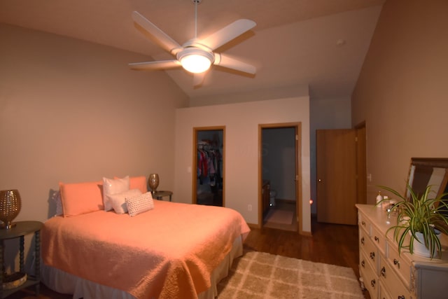 bedroom with a closet, wood finished floors, vaulted ceiling, a spacious closet, and a ceiling fan