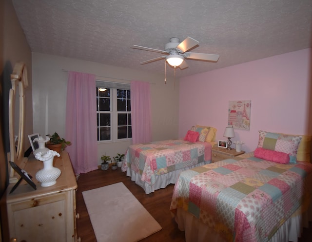 bedroom with ceiling fan, a textured ceiling, and wood finished floors