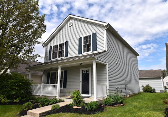 traditional-style home with covered porch and a front yard