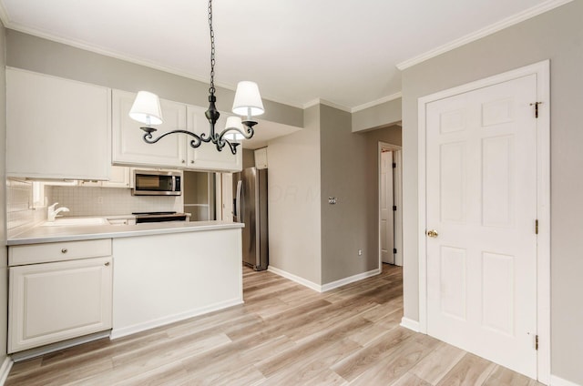 kitchen featuring light wood-style flooring, stainless steel appliances, a notable chandelier, backsplash, and light countertops