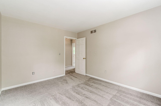 empty room with light carpet, baseboards, and visible vents