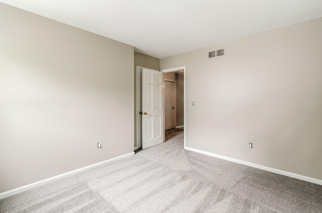 unfurnished bedroom featuring light colored carpet, visible vents, and baseboards