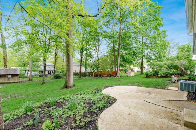 view of yard with a storage shed, a patio, fence, and an outbuilding