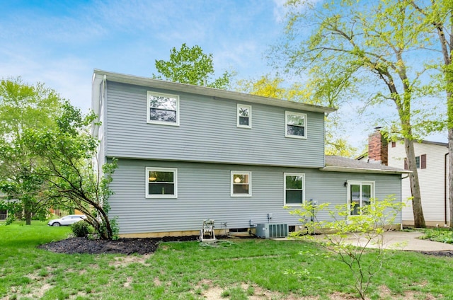 rear view of property featuring a yard, central air condition unit, a patio, and a chimney