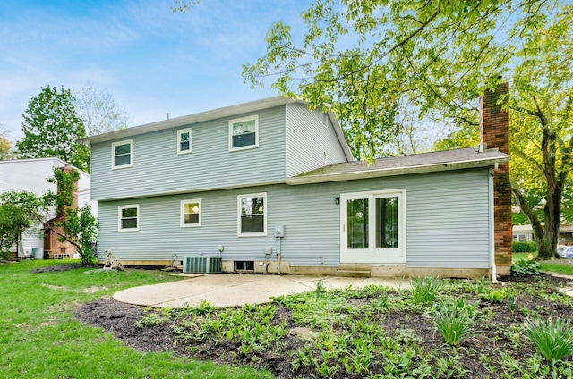 back of property with a chimney, cooling unit, a patio, and a yard