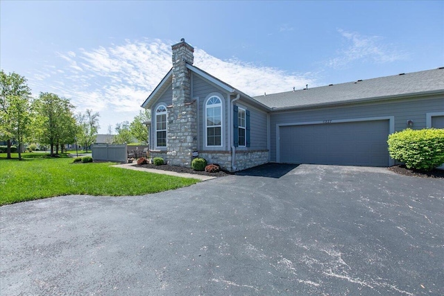 6227 Stonewalk Ln, New Albany, OH 43054 - ranch-style home with a chimney, driveway, a garage, stone siding, and a front lawn