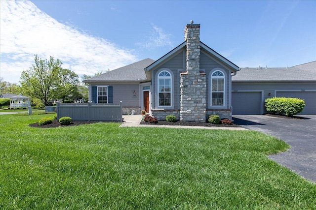 6227 Stonewalk Ln, New Albany, OH 43054 - ranch-style house with an attached garage, stone siding, a chimney, aphalt driveway, and a front yard