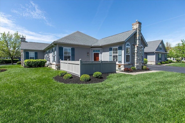 6227 Stonewalk Ln, New Albany, OH 43054 - exterior space with stone siding, a yard, roof with shingles, and a chimney