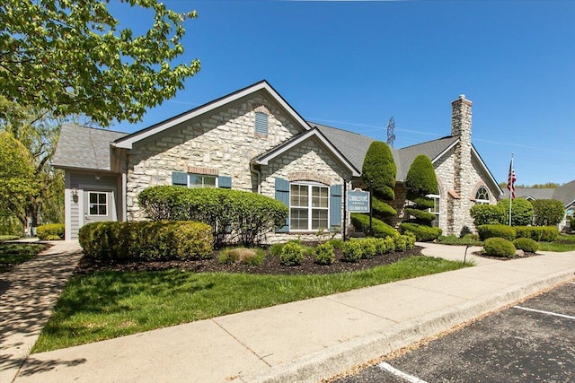 6227 Stonewalk Ln, New Albany, OH 43054 - view of front of house featuring a chimney, stone siding, and uncovered parking