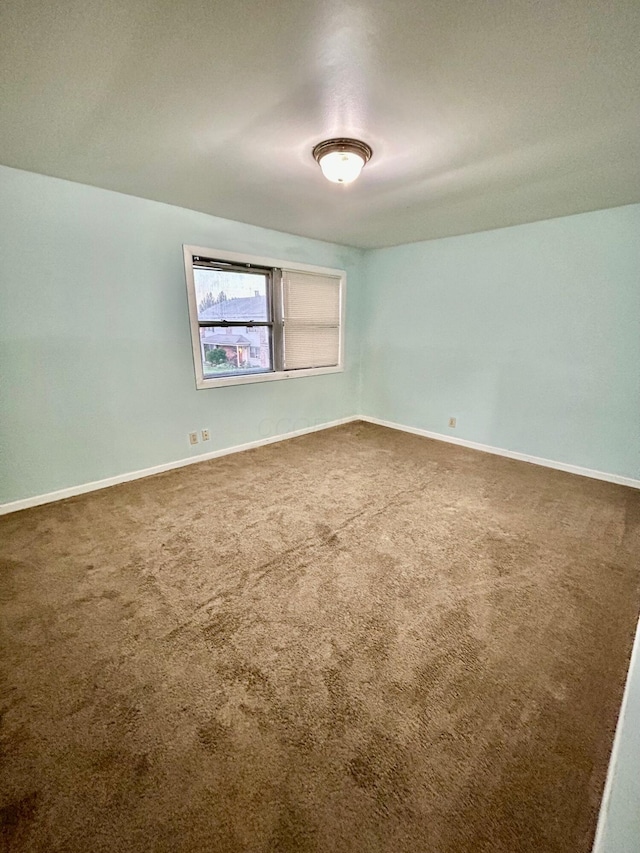 carpeted empty room with baseboards