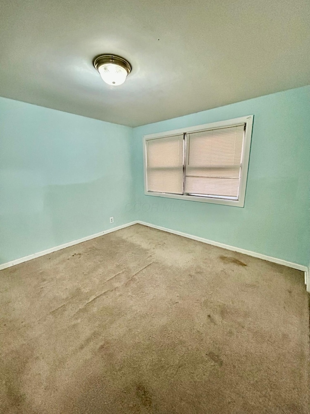 carpeted empty room with baseboards