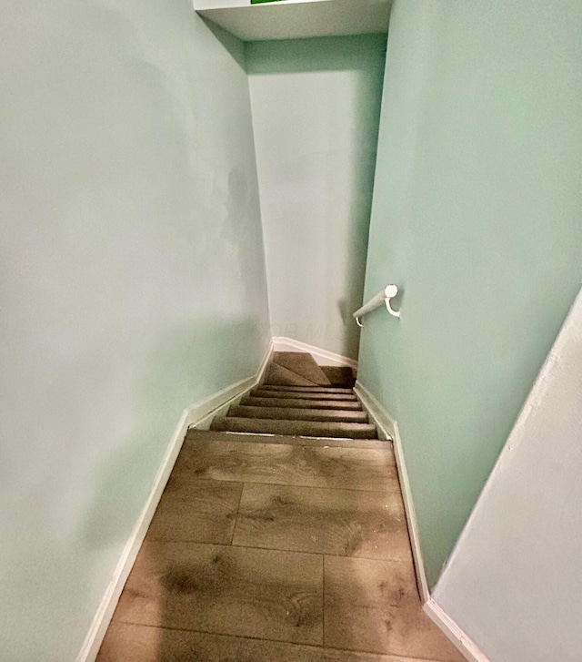 stairway featuring baseboards and wood finished floors