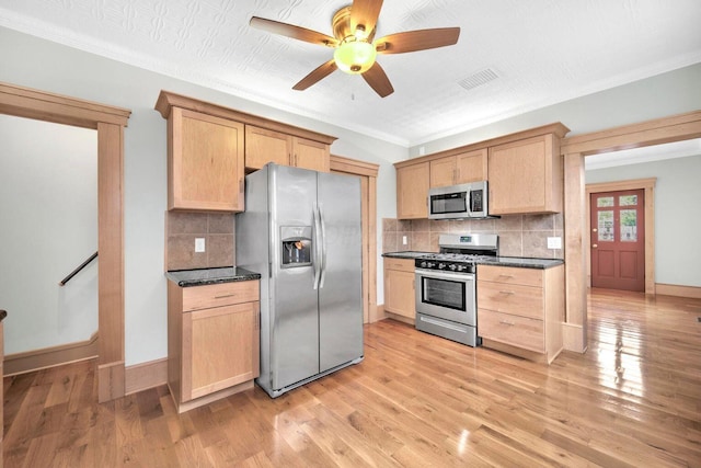 661-663 Beech St, Columbus, OH 43206 - kitchen featuring appliances with stainless steel finishes, dark countertops, a ceiling fan, light brown cabinetry, and ornamental molding