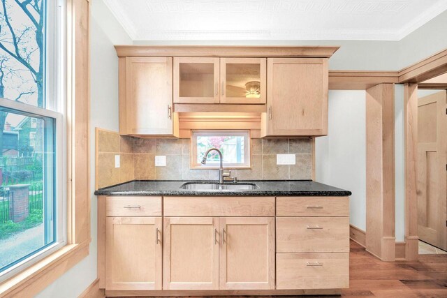 661-663 Beech St, Columbus, OH 43206 - kitchen with a sink, light brown cabinetry, ornamental molding, light wood finished floors, and dark stone counters