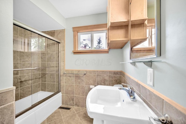 661-663 Beech St, Columbus, OH 43206 - bathroom with tile walls, bath / shower combo with glass door, tile patterned floors, and wainscoting