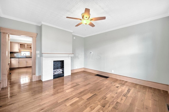 661-663 Beech St, Columbus, OH 43206 - unfurnished living room with a ceiling fan, a brick fireplace, light wood-style flooring, a sink, and ornamental molding