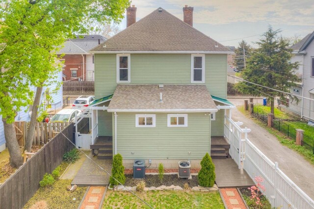 661-663 Beech St, Columbus, OH 43206 - back of property with a chimney, roof with shingles, central AC, and a fenced backyard