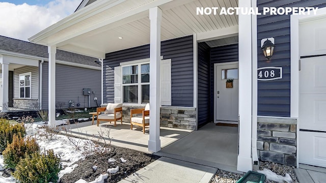 doorway to property with stone siding and covered porch