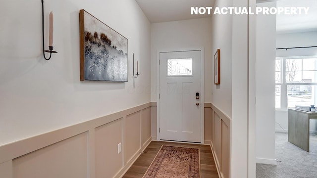 entryway featuring a decorative wall, a wainscoted wall, and wood finished floors