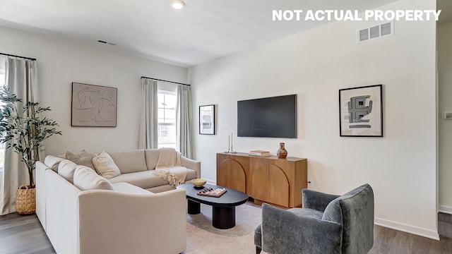 living room with baseboards, visible vents, and wood finished floors