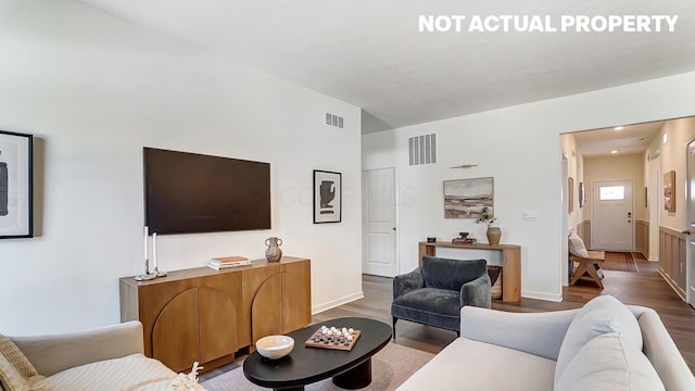 living area featuring visible vents and wood finished floors