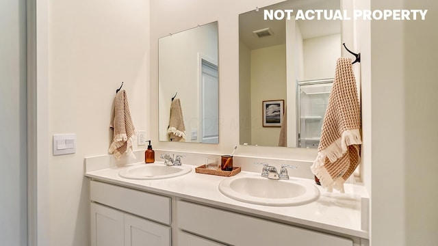 bathroom featuring double vanity, visible vents, and a sink