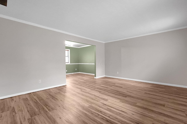 unfurnished room with baseboards, ornamental molding, and wood finished floors